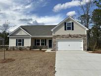 Beautiful single-story home featuring stone accents, a two-car garage, and a well-manicured lawn at 4761 Huckleberry Ln., Conway, SC 29526
