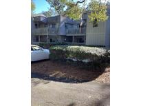 Charming condo building with grey siding, featuring private balconies and mature landscaping at 118 Salt Marsh Circle # 25B, Pawleys Island, SC 29585