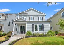 Charming two-story home with a welcoming porch, manicured lawn, and classic architectural details under a blue sky at 219 West Palms Dr., Myrtle Beach, SC 29579