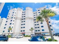 Stunning exterior view of a multi-story condo building with palm trees in front at 5800 N Ocean Blvd. # 705, North Myrtle Beach, SC 29582