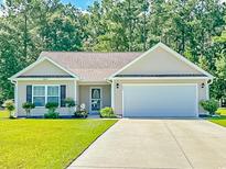 Beige house with brown roof, attached garage, and landscaped lawn at 252 Timber Run Dr., Georgetown, SC 29440
