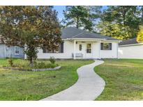 White house with landscaped lawn and walkway at 6625 Scotsman Crescent, Myrtle Beach, SC 29588