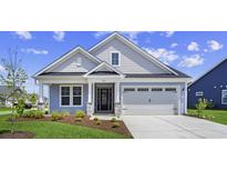 Charming single-Gathering home boasts a two-car garage, well-manicured lawn, and inviting front entrance at 5001 Cambria Ct., Little River, SC 29566