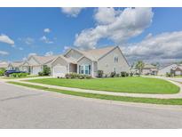 Charming single-Gathering home featuring a well-manicured lawn, vinyl siding, and attached one car garage at 1266 Brighton Hill Ave., Myrtle Beach, SC 29588