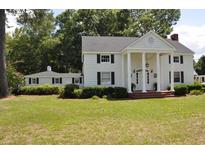 White house with black shutters, columns, and a large front yard at 5632 Main St., Loris, SC 29569