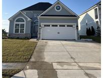 Two-story home showcasing a white garage door, arched windows, and blue-grey facade at 190 Palmetto Harbour Dr., North Myrtle Beach, SC 29582