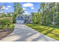 House exterior featuring a two-car garage and a landscaped lawn at 202 Rivers Edge Dr., Conway, SC 29526