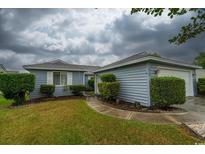 Charming home with a well-maintained lawn, neatly trimmed shrubs, and an inviting pathway to the front door at 213 Birkdale Ln., Myrtle Beach, SC 29588