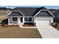 Charming one-story home featuring a black roof, white siding, and a spacious two-car garage at 1215 Mill Banks Dr., Longs, SC 29568