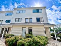 Two-story condo building with attractive landscaping and a paved walkway at 209 75Th Ave. N # 10, Myrtle Beach, SC 29572