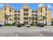 Inviting condo building with multiple balconies, palm trees, manicured landscaping, and ample parking at 601 Hillside Dr. N # 2903, North Myrtle Beach, SC 29582