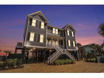 Stunning raised beach home featuring dual staircases, ample parking, and coastal charm at 1907 S Waccamaw Dr., Garden City Beach, SC 29576
