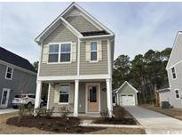 Charming two-story home with a light brown exterior, white trim, shutters, and a quaint front porch at 2645 Rowyn St., Longs, SC 29568