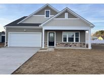 Two-story house with beige and brown siding, white garage door, and landscaping at 714 Night Lotus Dr., Calabash, NC 28467