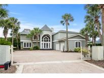 Stunning two-story home features a brick driveway, towering palm trees, and a grand entrance at 8000 Beach Dr., Myrtle Beach, SC 29572