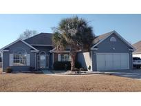 Charming one-story home featuring classic design elements and a well-maintained yard with mature tree at 1573 Southwood Dr., Surfside Beach, SC 29575
