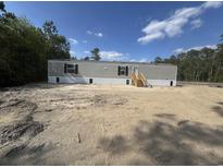 Newly constructed single story home with gray siding and stairs to the front entrance in a wooded area at 2500 Newton Rd., Aynor, SC 29511