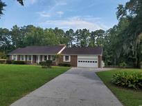 Charming brick ranch with well-maintained lawn and attached garage in a serene, tree-lined setting at 5864 Crestwood Dr., Myrtle Beach, SC 29578