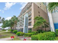 View of the Grande Shores oceanfront resort hotel with palm trees and manicured landscaping at 201 77Th Ave. N # 720, Myrtle Beach, SC 29577