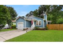 Charming blue single-story home with a well-manicured front lawn, white trim, and attached one car garage at 4115 Little River Rd., Myrtle Beach, SC 29577