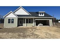 Charming one-story home with sage siding, white trim, and an attached two-car garage at 107 Infinity Ln., Loris, SC 29569