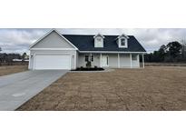 Gray house with white garage door and landscaping at 111 Infinity Ln., Loris, SC 29569