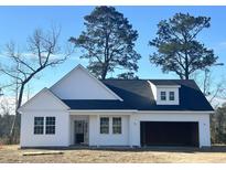 Charming, modern farmhouse exterior with a two-car garage and dormer windows at 112 Infinity Ln., Loris, SC 29569
