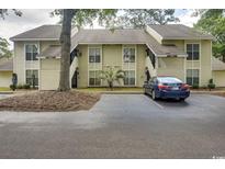 Two-story condo with yellow siding, a tree in the front, and a car parked in the parking lot at 4450 Little River Inn Ln. # 608, Little River, SC 29566