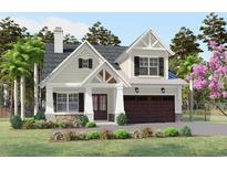 Charming two-story home featuring a covered porch with stone accents and a two-car garage at 409 N Highland Way, Myrtle Beach, SC 29572