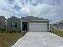 Charming single-story home showcasing a well-manicured lawn, a two-car garage and neutral-toned exterior paint at 318 Cheerful Way, Little River, SC 29566