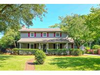 Charming two-story home featuring a well-manicured lawn and a welcoming front porch with detailed trim and red shutters at 7602 Glenwood Dr., Myrtle Beach, SC 29572