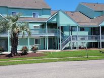Attractive teal condo complex with palm trees, well-maintained landscaping, and inviting outdoor access at 1930 Bent Grass Dr. # 40K, Surfside Beach, SC 29575