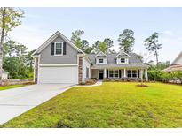 Two-story home with gray siding, white garage door, and landscaped lawn at 790 Caines Landing Rd., Conway, SC 29526