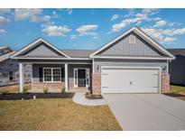 Gray house with brick accents, white columns, and a two-car garage at 1124 Cypress Shoal Dr., Conway, SC 29526