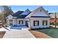 White brick house with a gray roof, black windows, and a two-car garage at 4336 Parkland Dr., Myrtle Beach, SC 29579