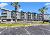 Low-rise condos with ample parking and palm trees under a clear blue sky at 6000 N Ocean Blvd. # 330, North Myrtle Beach, SC 29582