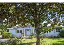 Charming single-story home with a light blue exterior, front-facing entry, and mature landscaping at 11660 Highway 90, Little River, SC 29566