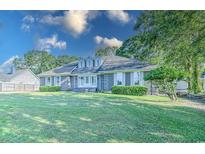 Brick house with a spacious lawn and mature trees at 1437 Shoreline Dr., Myrtle Beach, SC 29577