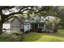 Charming single-Gathering home featuring a manicured lawn, attached garage, and welcoming front porch at 290 Rybolt Rd., Pawleys Island, SC 29585