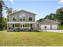 Charming gray two-story home with a welcoming front porch and detached two-car garage at 1270 Circle Bay Dr., Longs, SC 29568