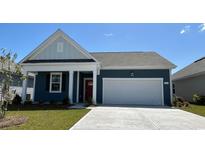 Charming single-story home featuring blue siding, a red door, and an attached two-car garage at 543 Duvall St., Longs, SC 29568