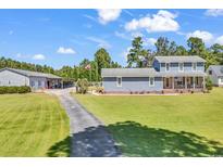 Charming two-story home featuring a lovely front porch, attached garage, and a well-manicured lawn on a sunny day at 3747 Bakers Chapel Rd., Aynor, SC 29511