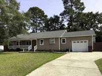 Charming home featuring a well-manicured lawn, front porch and an attached garage at 104 Sprucewood Ct., Myrtle Beach, SC 29588
