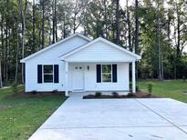 Charming single-story home with white siding, black shutters, and a well-manicured front yard at 74 Greentown Rd., Georgetown, SC 29440