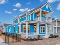 Charming blue two-story home with white trim, a cozy front porch, and a second story balcony at 8111 Laurel Ash Ave., Myrtle Beach, SC 29572