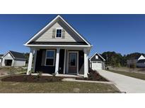 Charming home with a craftsman style, a tidy yard, and a detached garage at 9100 Mabel Ct., Longs, SC 29568