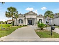 Stunning home exterior with palm trees, a circular driveway and meticulously landscaped front yard at 202 Ave. Of The Palms, Myrtle Beach, SC 29579