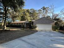 Brick ranch home with attached garage and a large driveway at 902 N 11Th Ave. N, North Myrtle Beach, SC 29582
