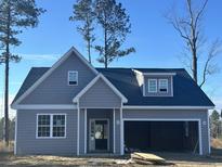Charming gray home featuring a two-car garage and a welcoming front porch at 116 Infinity Ln., Loris, SC 29569
