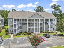 Inviting condominiums feature white pillars, multiple floors, and convenient parking for easy access at 5810 Longwood Dr. # 14-304, Murrells Inlet, SC 29576